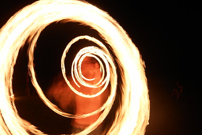 I sincerely hope I can get another photograph like this one day, zooming in on the spinner so that we see multiple versions of him within a spiral of fire.  The first problem with using zoom like this is that you need a long enough exposure to work the zoom, pausing a couple of times. But a long exposure and flames means and overexposed image.

The second problem is that you need to have a reasonably good idea about what the dancer is going to be doing during the exposure.