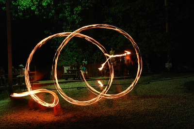 Sometimes, though, a longish exposure brings out both the wonderful pattern created by the spinner and the frozen aspect of the watchers.  This is Keile working his dart, a ball of fire at the end of a 15 foot long rope and chain affair.  What I like is how clearly he is dancing, even though you can't see him.